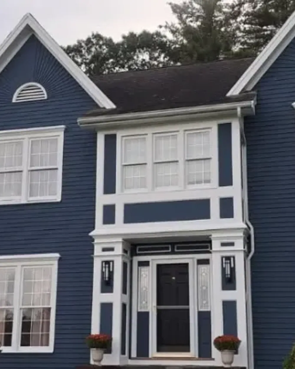 Navy New England colonial with crisp white trim, exterior repaint by Milena Construction