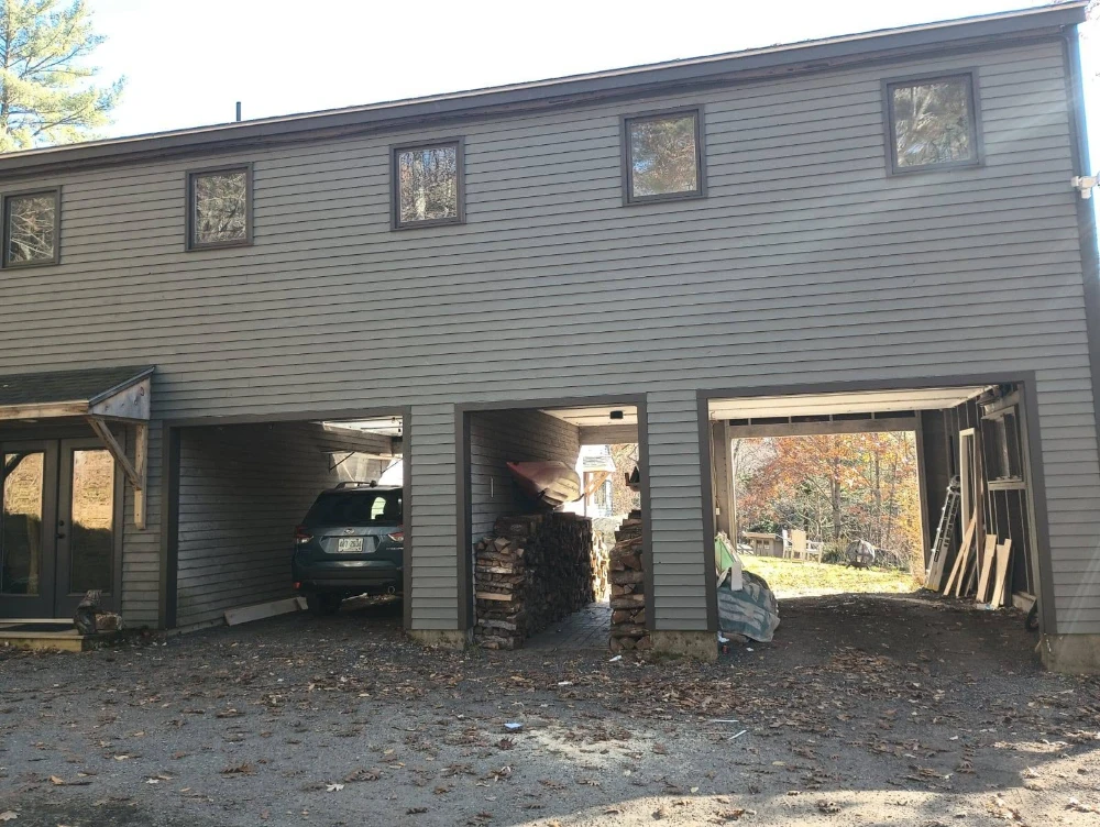Exterior renovation in progress on a multi-bay New England home