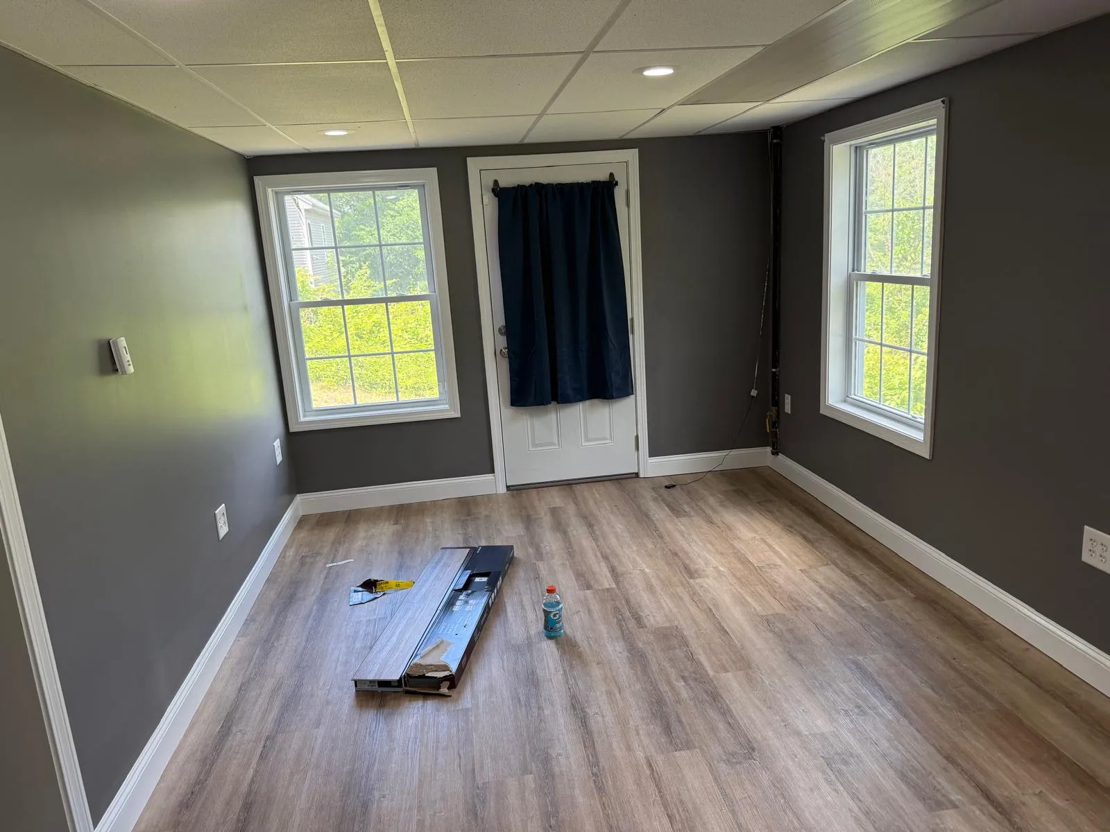 Living room with freshly installed vinyl plank flooring and gray walls