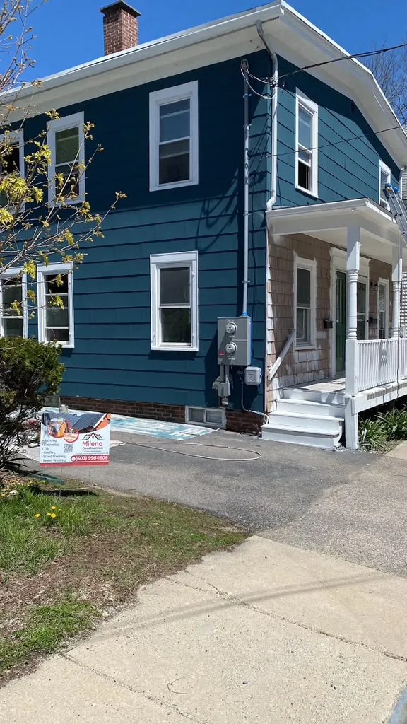 Two-story home repainted in blue with white trim