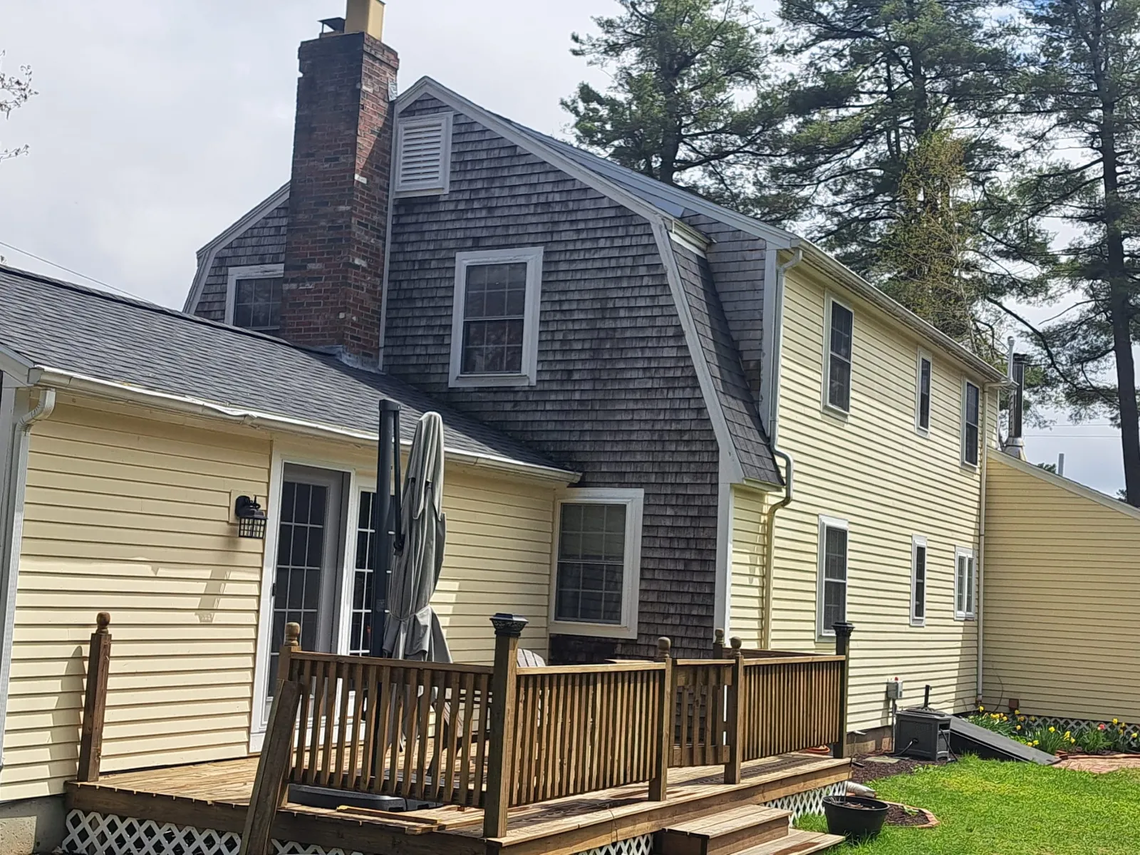 New England home with cedar shingle siding and a backyard deck