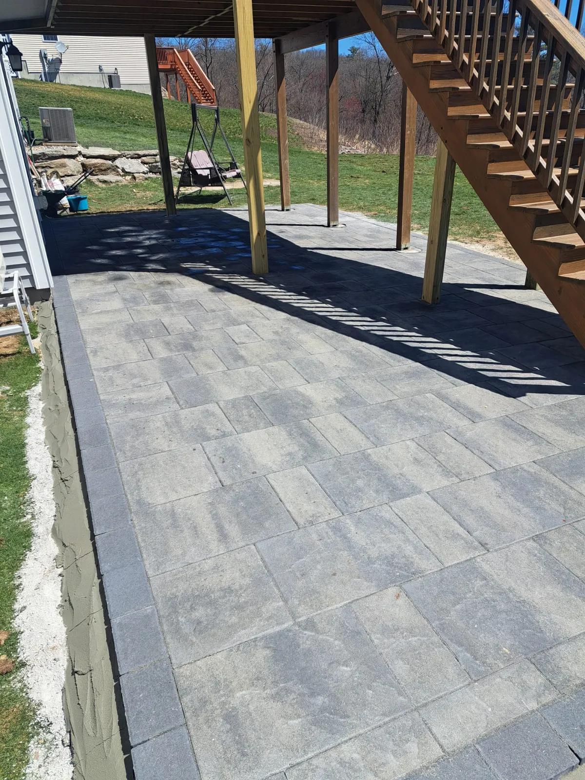 Paver walkway and steps leading to a backyard deck
