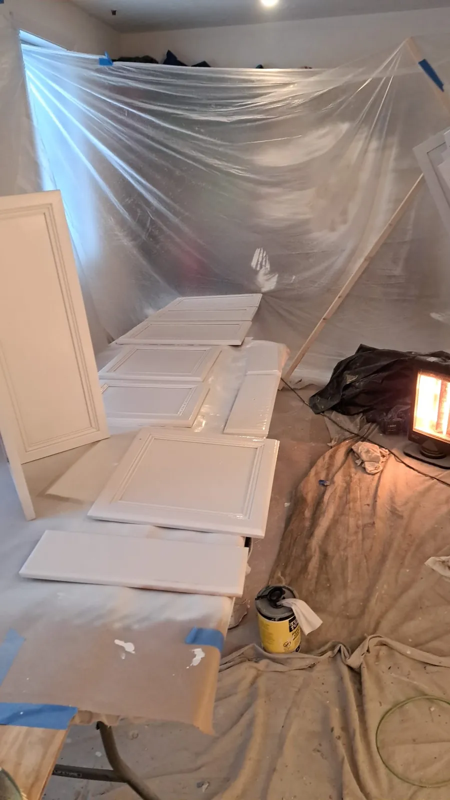Room masked and protected with plastic sheeting before painting
