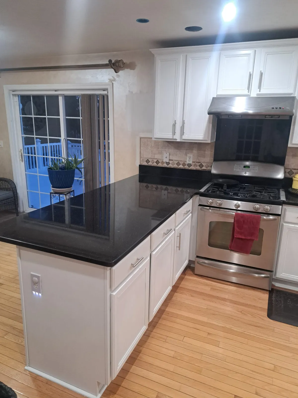 Finished kitchen with white cabinets, black counters and stainless appliances
