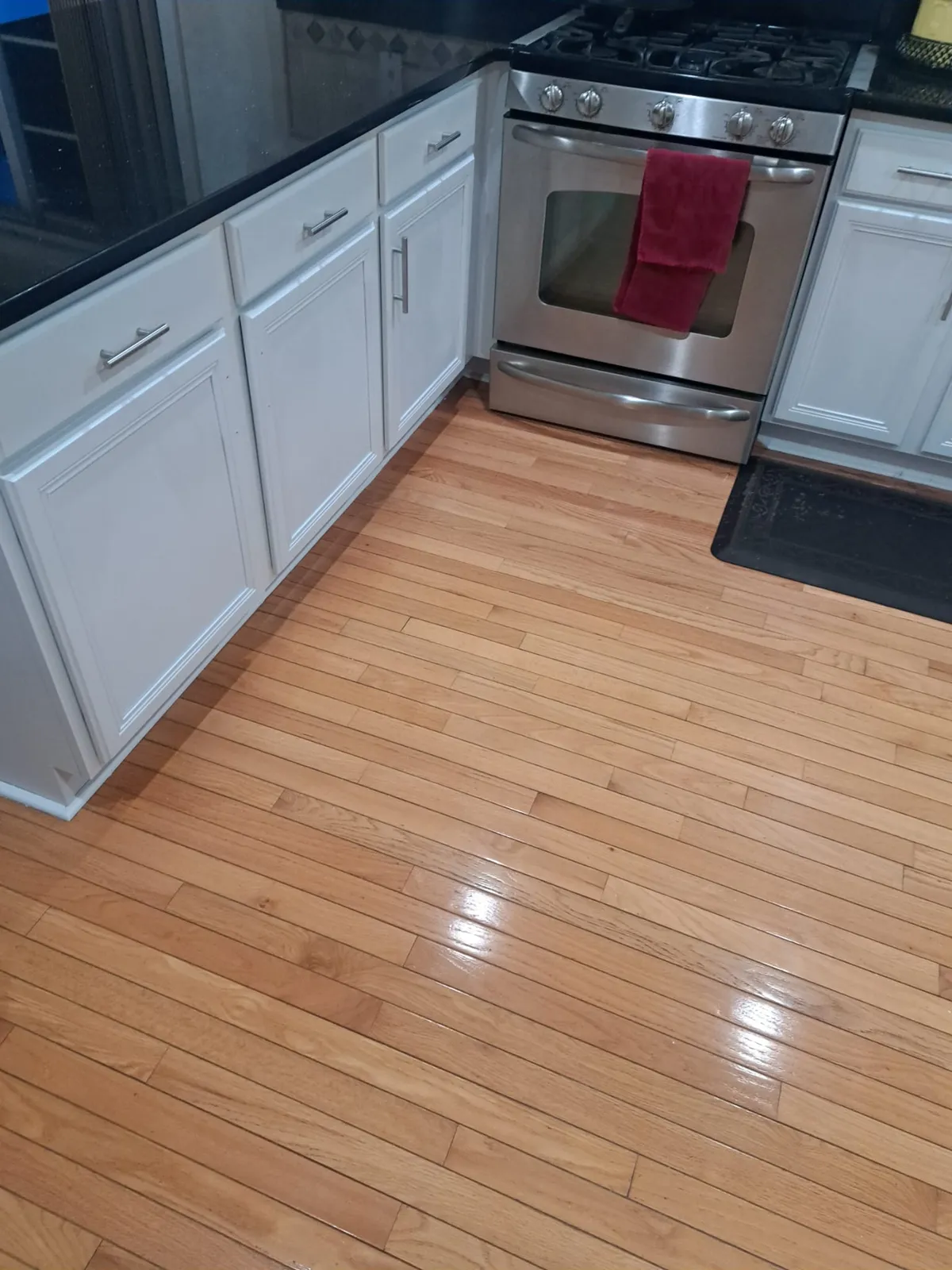 Kitchen with white cabinetry and hardwood flooring