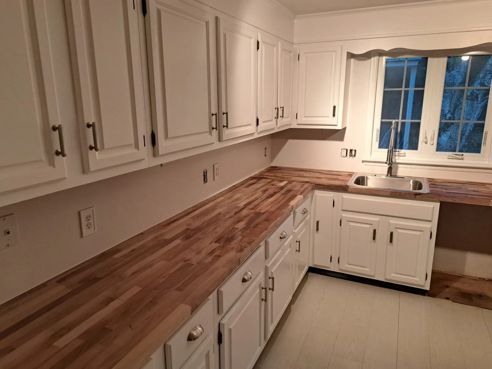 Finished white kitchen with butcher block countertops