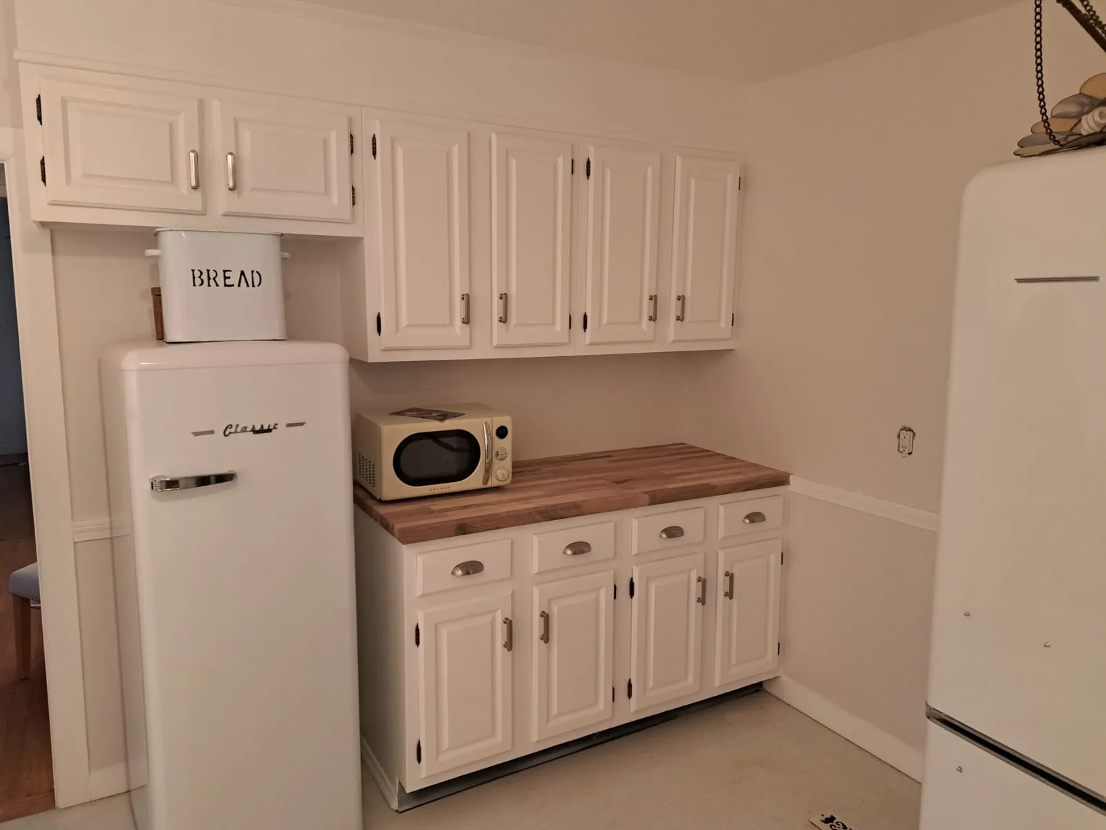 White kitchen with a retro refrigerator and butcher block counters
