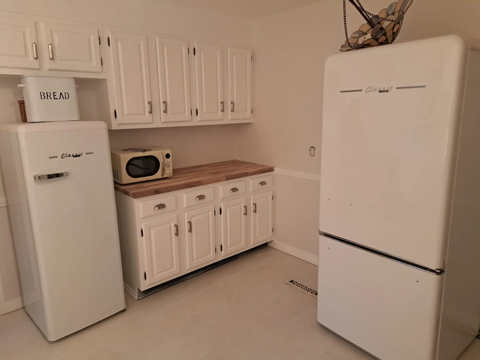 Remodeled kitchen with white cabinets and wood countertops
