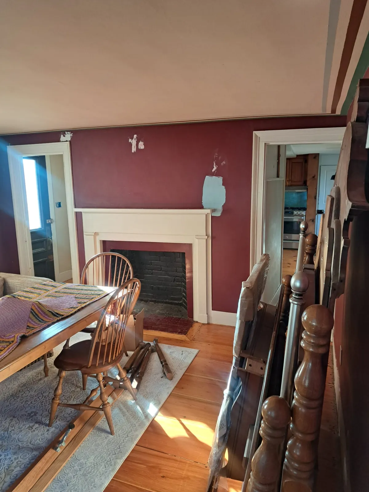 Dining room with a bold red accent wall and hardwood floors