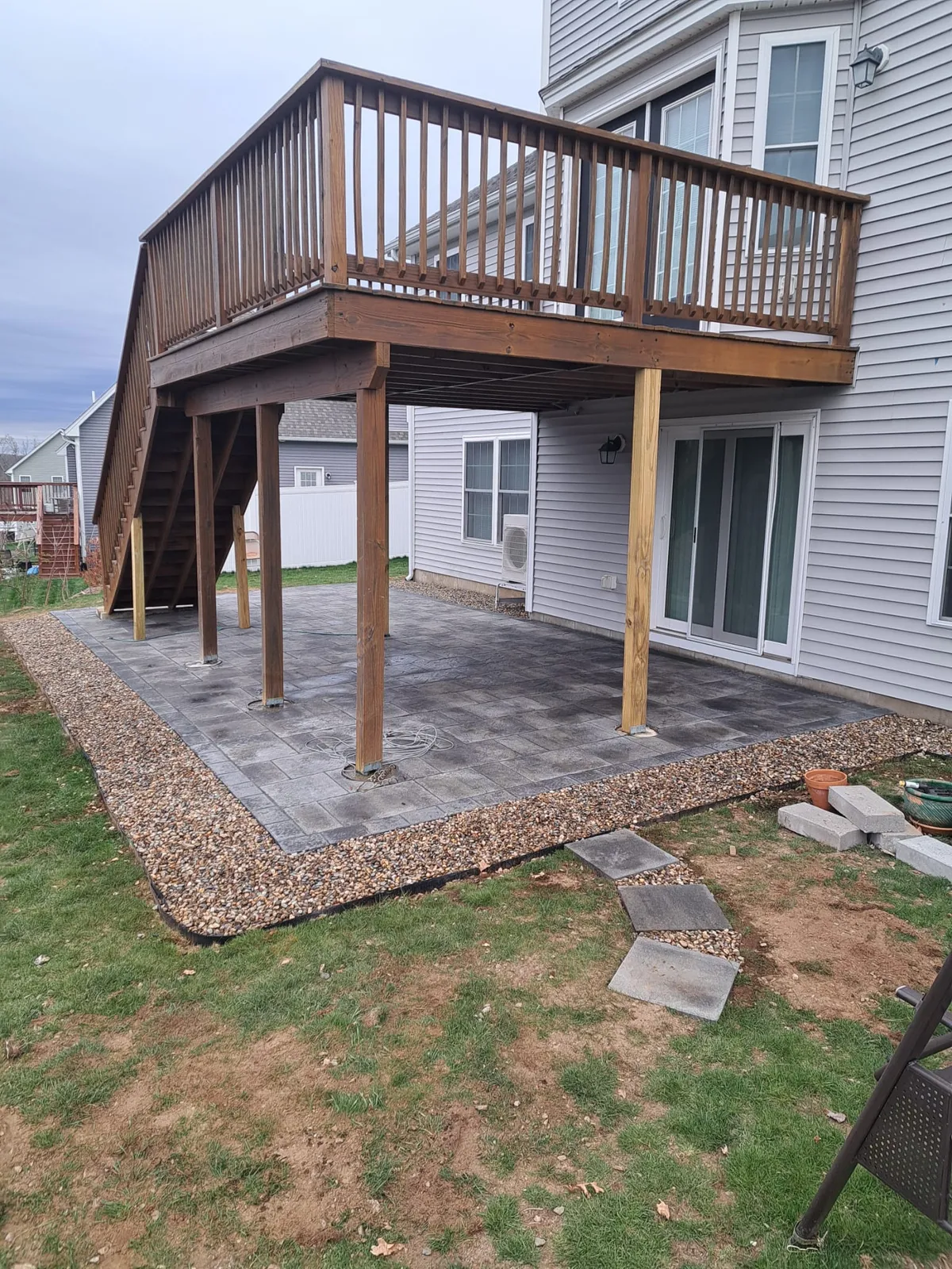 Elevated wooden backyard deck with stairs and railing