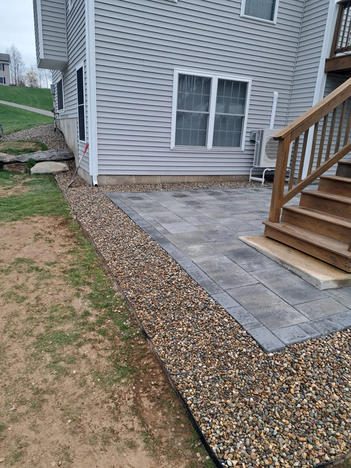 Paver path and deck steps in a backyard
