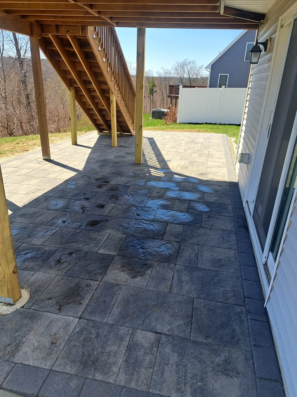 Covered paver patio under an elevated deck