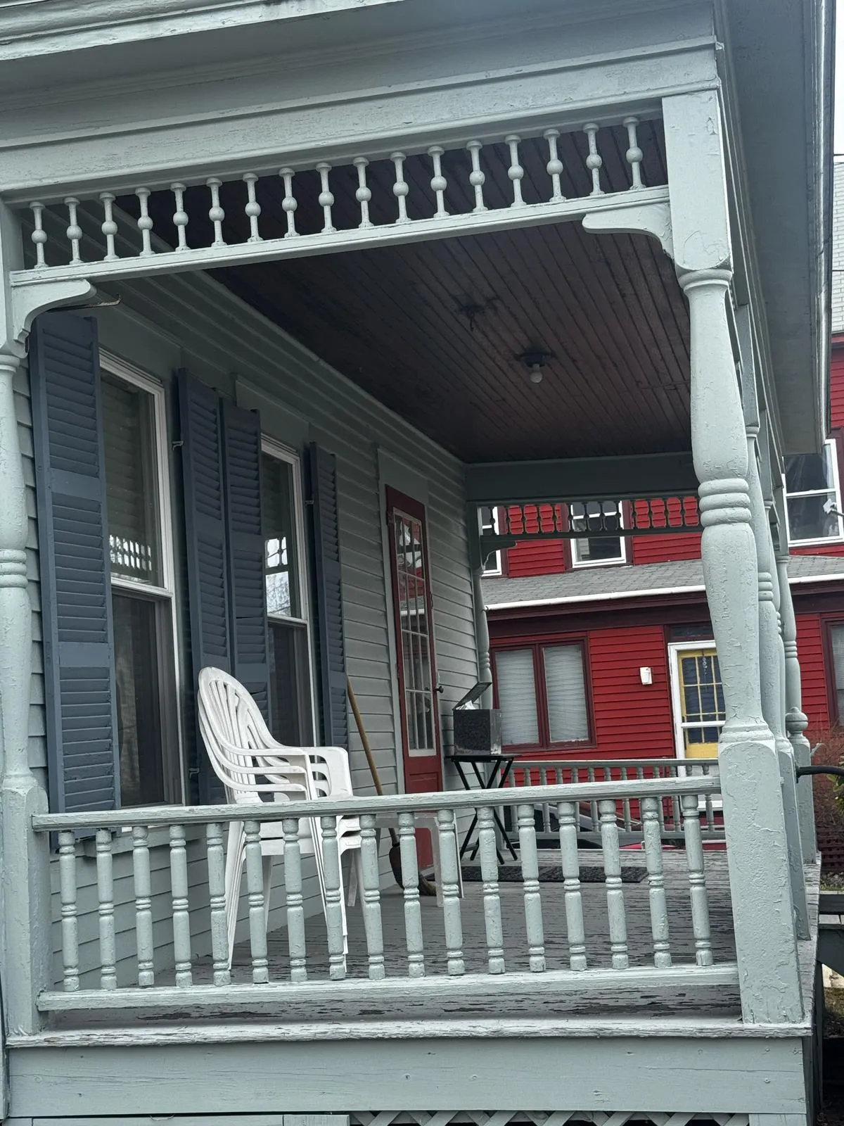 Restored front porch with gray flooring and white railings