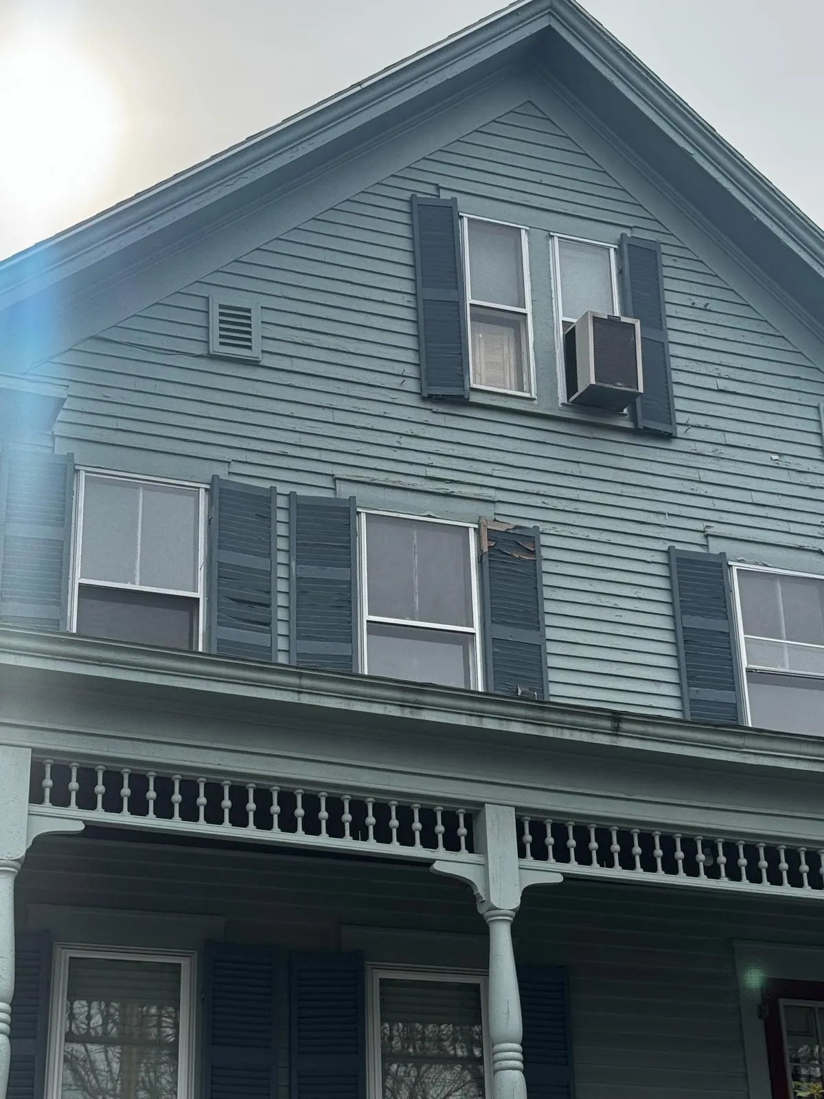Gray multifamily home with a covered front porch