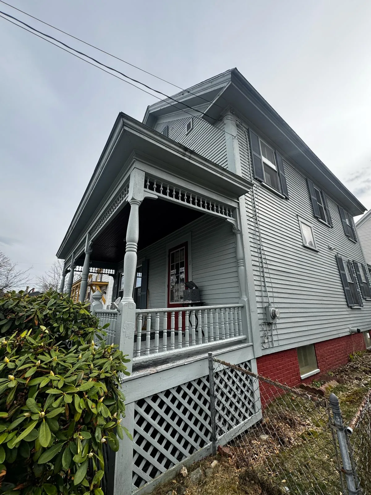 Gray New England home with a full-width front porch