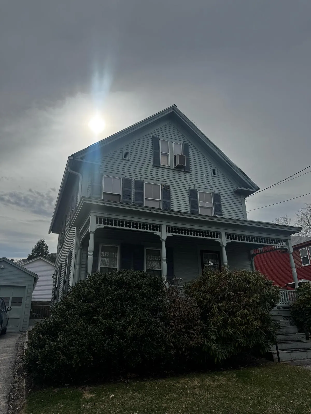 Gray two-story home with a front porch and bay windows