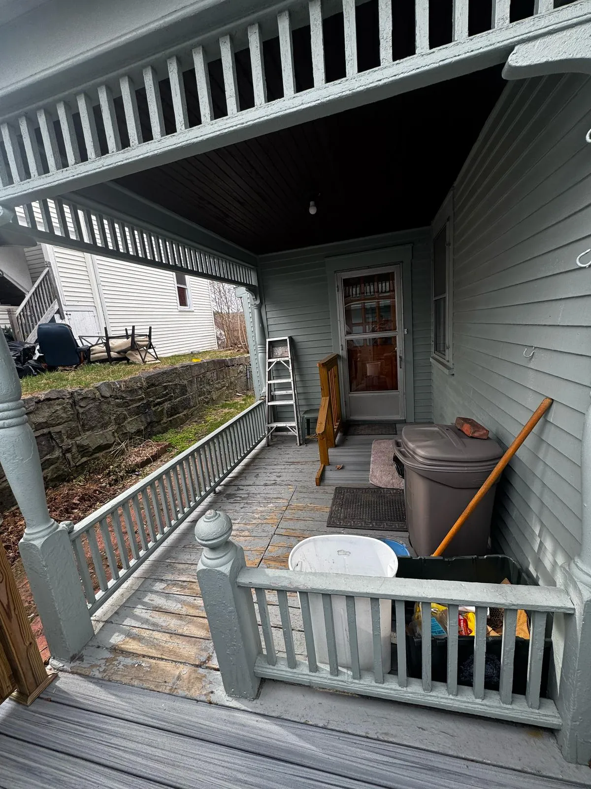Covered porch with turned columns and gray decking