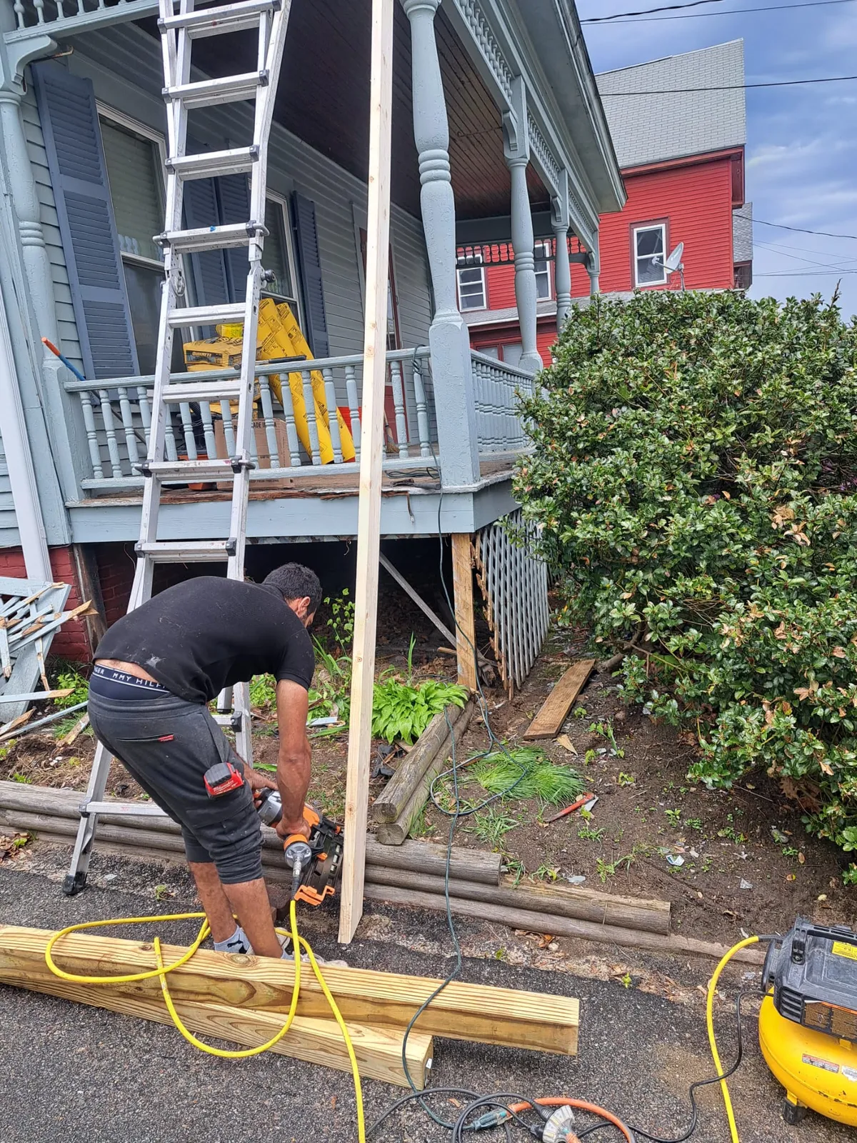 Carpenter cutting lumber during a porch rebuild