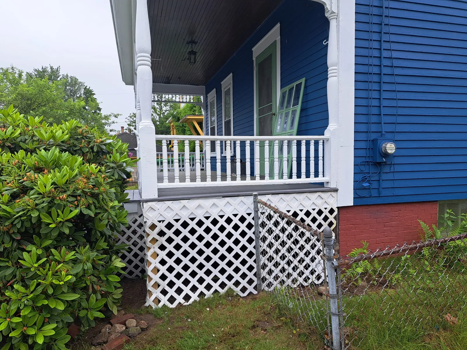 White porch railing against a freshly painted blue home
