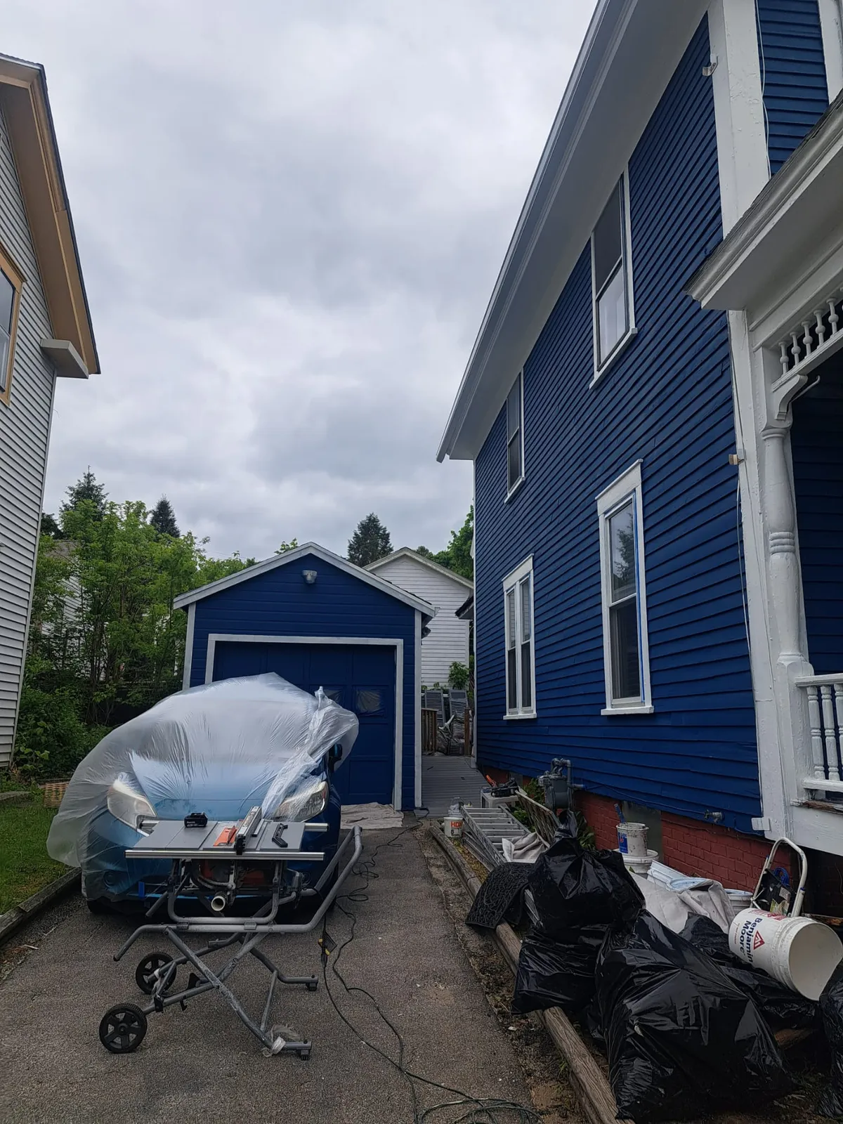 Side of a blue home with garage and walkway after painting