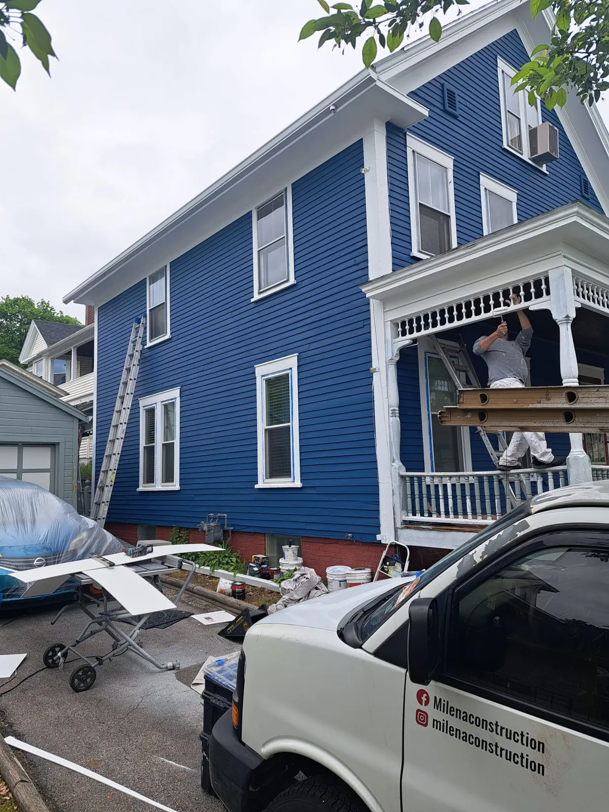 Milena Construction truck at a blue home exterior job