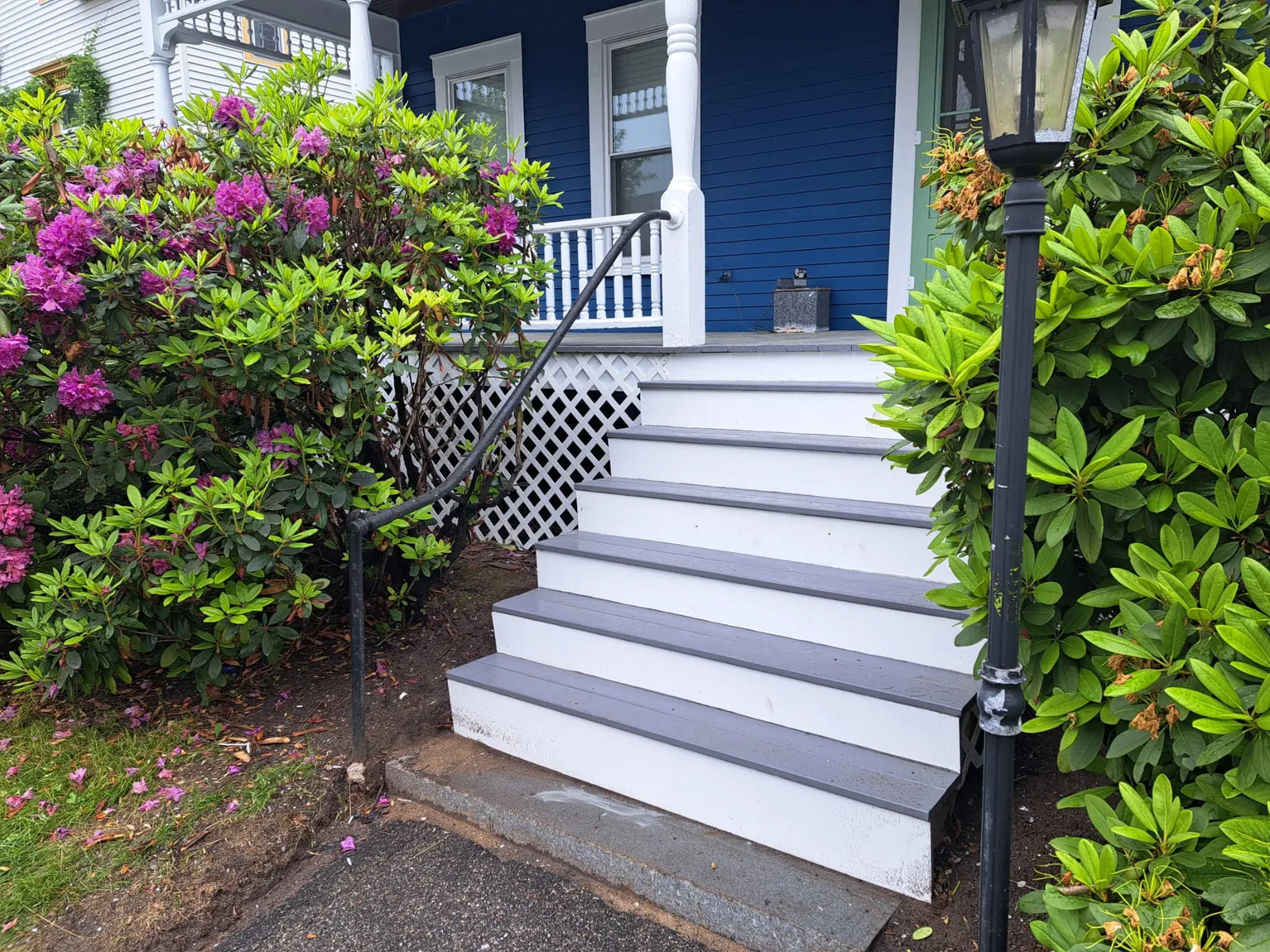 Freshly painted porch steps and railing with spring blooms