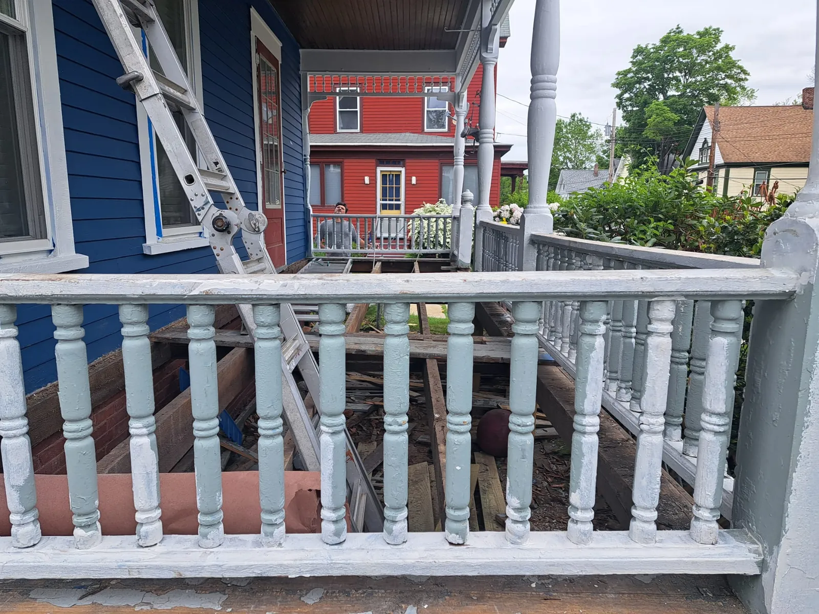 Hand-painting white porch balusters during an exterior job