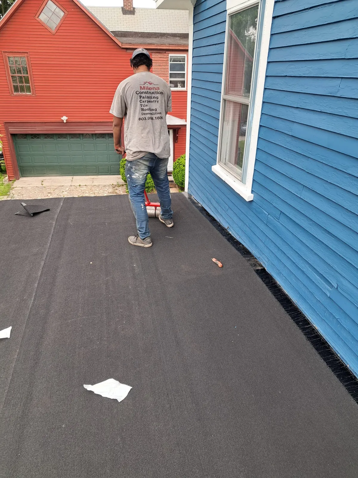 Crew member working along a blue home exterior