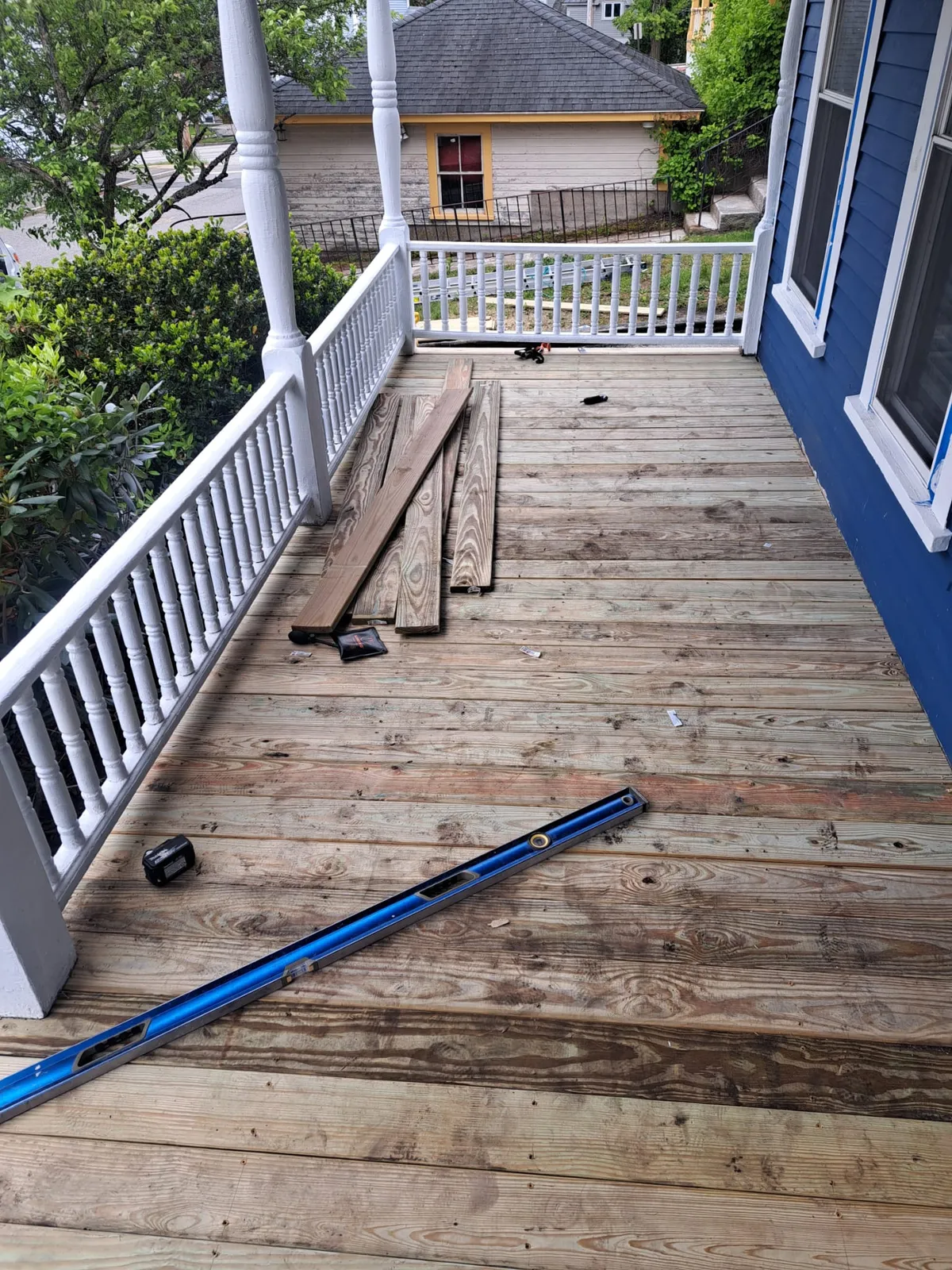Newly rebuilt wood deck off a blue home
