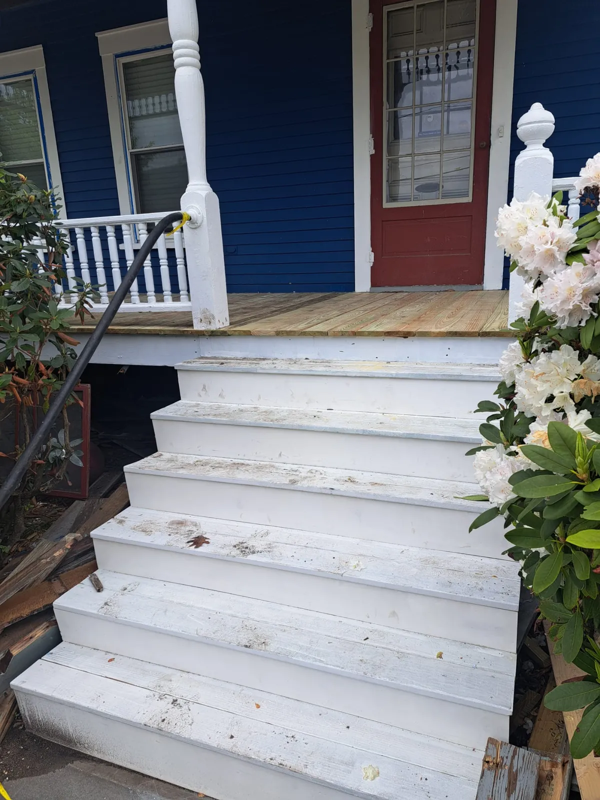 White porch steps with a red front door