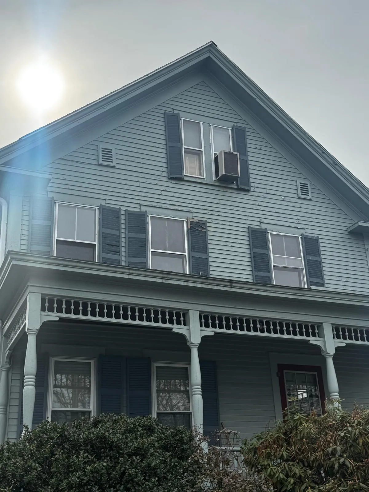 Light blue multifamily home with covered front porches