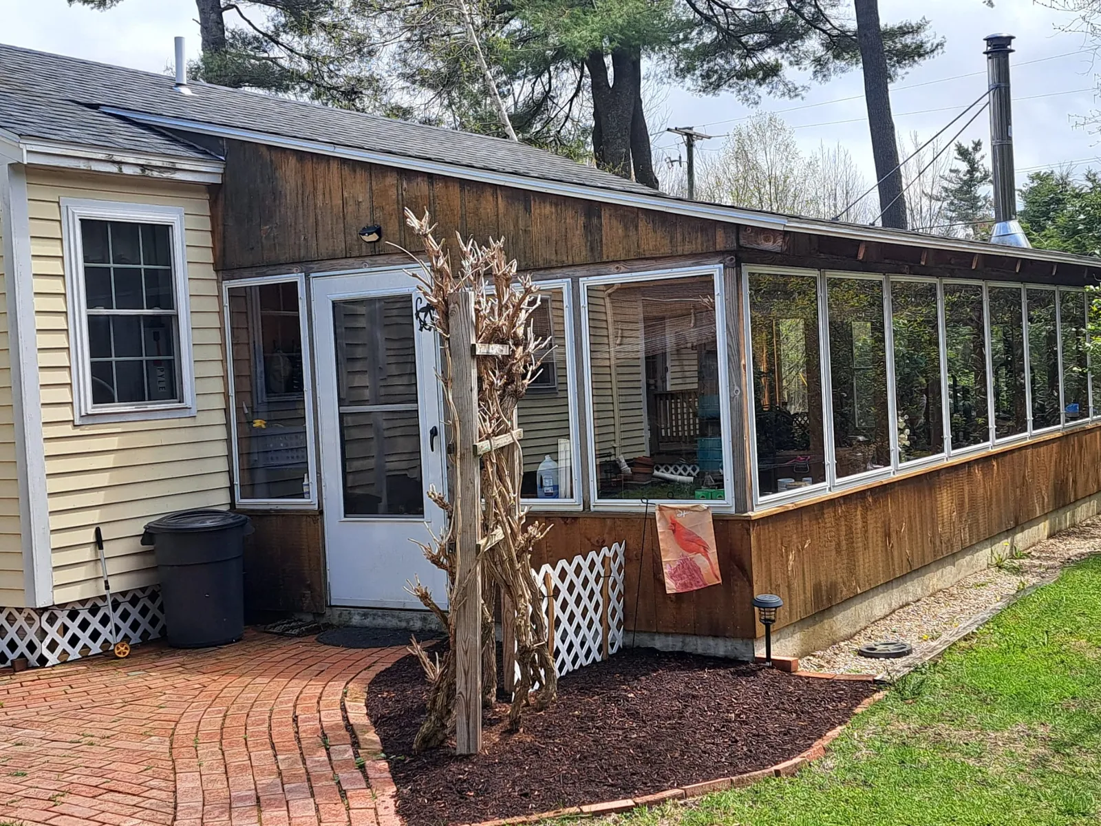 Ranch home with a sunroom and a brick paver walkway
