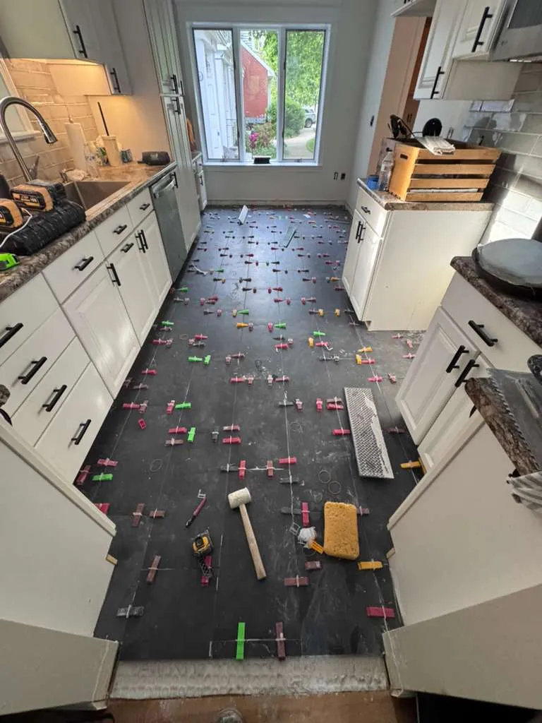 New floor tile being laid in a kitchen