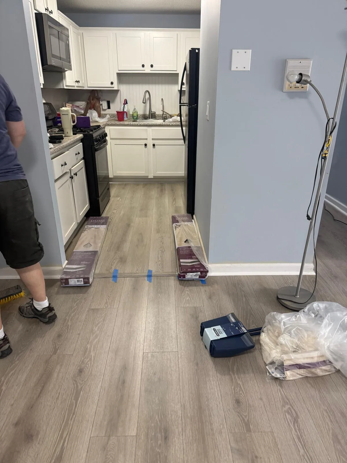 New vinyl plank flooring being installed in a kitchen