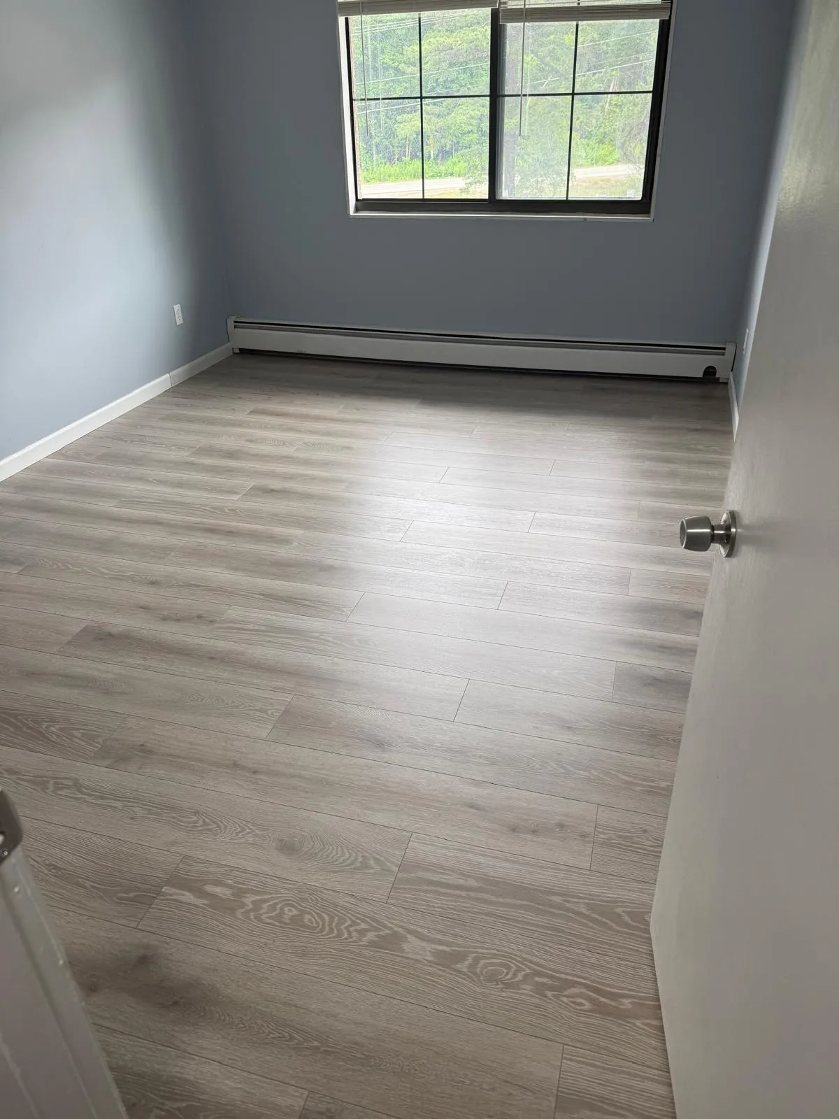 Empty room with new luxury vinyl plank and gray walls