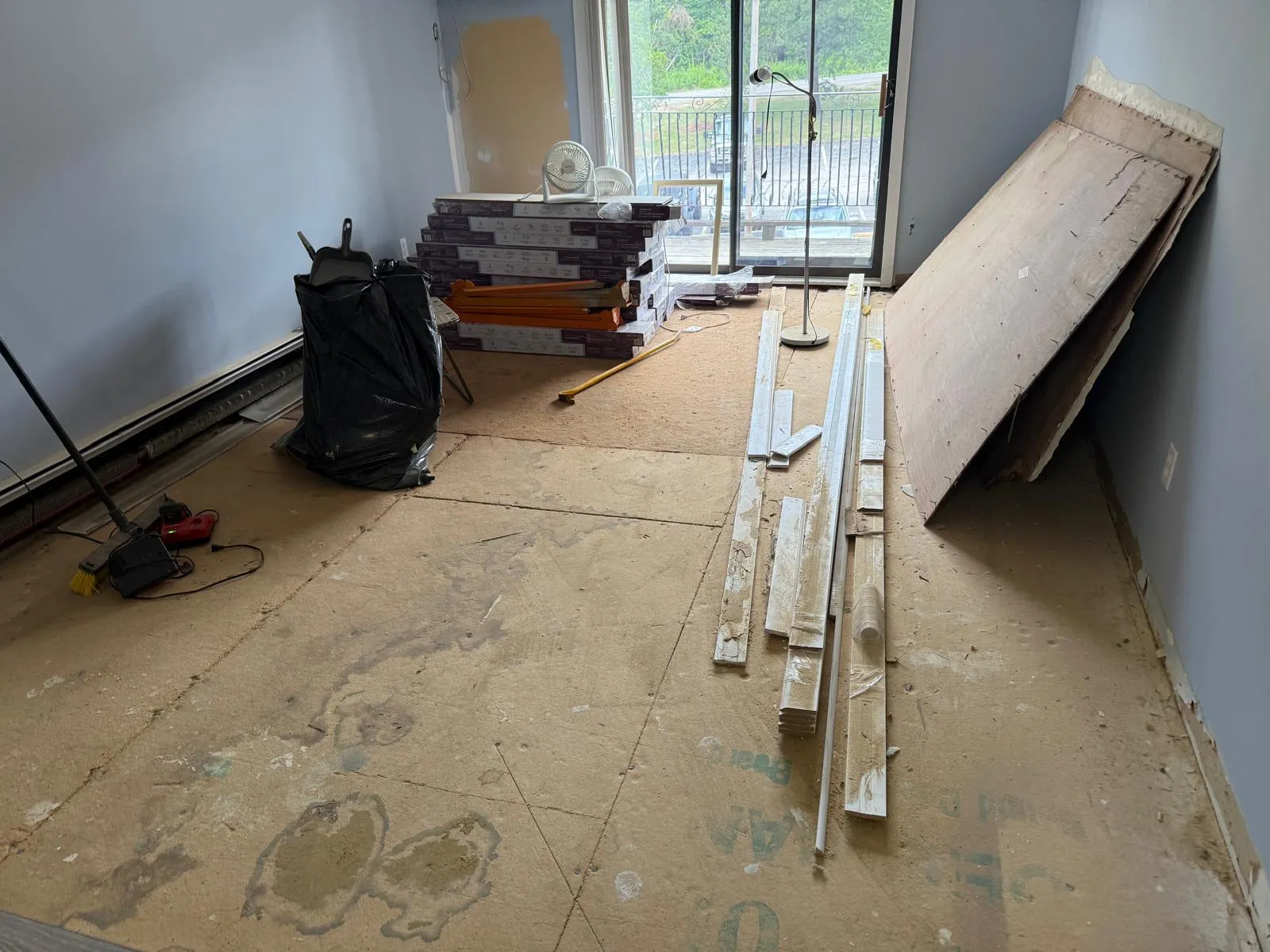 Room prepped with baseboard and flooring materials staged