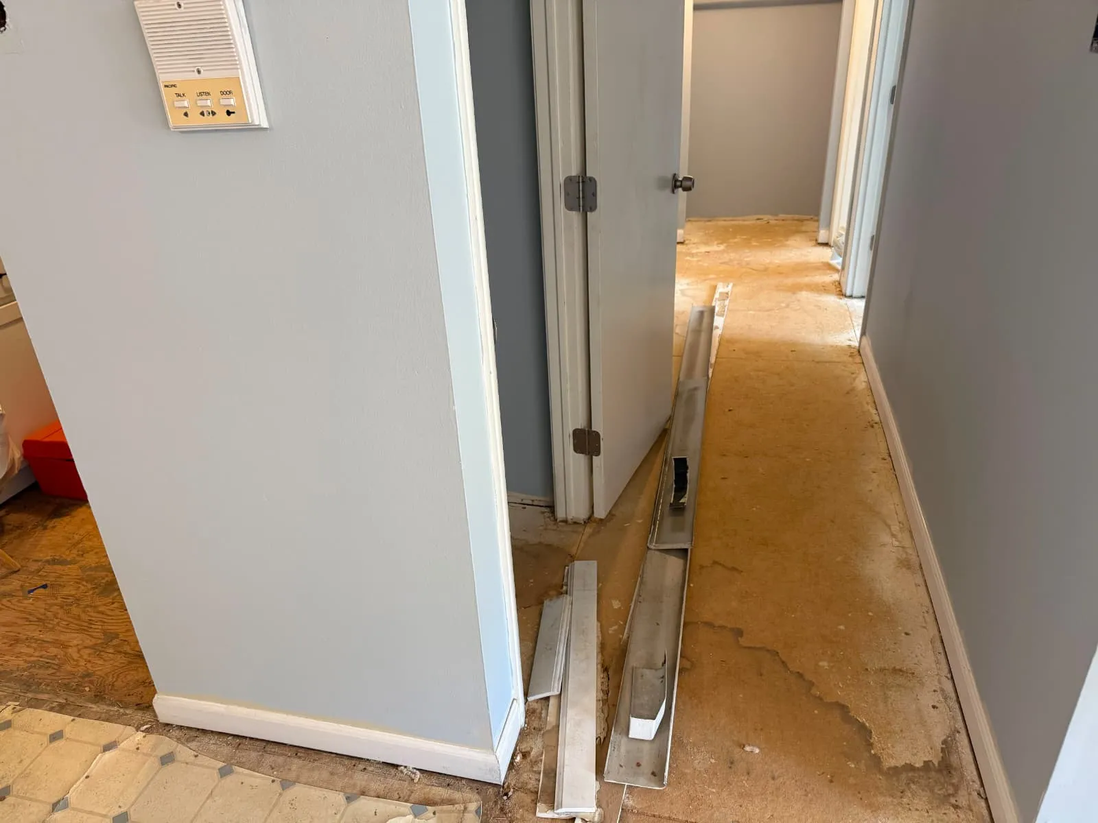 Flooring and baseboard installation in a hallway