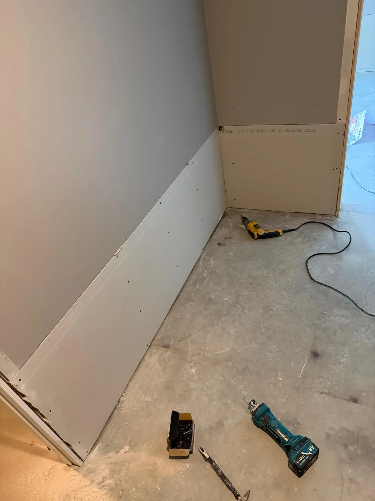 New baseboard trim installed along a fresh floor
